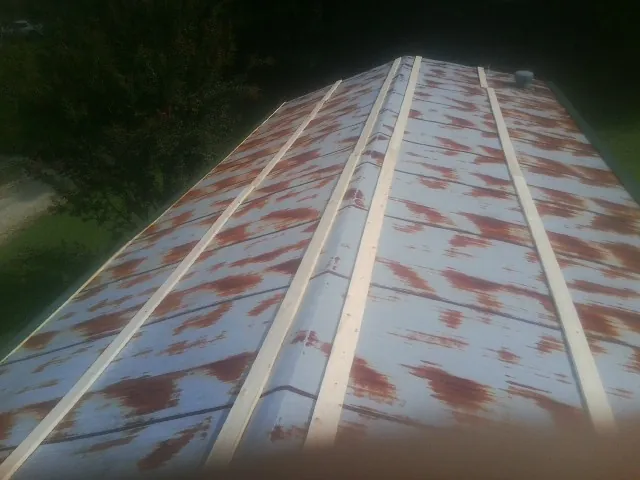 Rusted metal roof panels with new wood purlins before replacement — Storm Damage Roof Repair in Prince George by Roofing Brothers