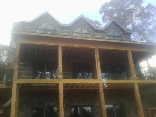 Dormers and porch framing on a large log home under construction — Roof Coating work by our crew in Prince George